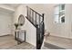 Elegant staircase featuring dark wood railings and light wood stairs, complemented by natural light from a nearby window at 1724 E Bridgeport Pkwy, Gilbert, AZ 85295