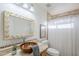 Stylish bathroom features a vessel sink, decorative mirror, and neutral tile in the shower at 1780 E Countrywalk Ln, Chandler, AZ 85225