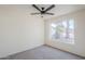 Neutral bedroom with a large window providing natural light and a ceiling fan for comfort at 1780 E Countrywalk Ln, Chandler, AZ 85225