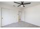 Clean bedroom features neutral walls, carpet, ceiling fan, and closet with sliding doors at 1780 E Countrywalk Ln, Chandler, AZ 85225