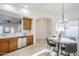 Open eat-in kitchen featuring stainless steel appliances, wood cabinetry, and travertine flooring at 1780 E Countrywalk Ln, Chandler, AZ 85225