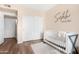 Cozy Bedroom with a white crib, closet, and wood-look flooring at 1825 W Ray Rd # 1148, Chandler, AZ 85224