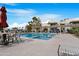 Community pool area featuring seating, a spa, a ramada and lush tropical landscaping at 1825 W Ray Rd # 1148, Chandler, AZ 85224