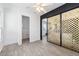 Bright bedroom features wood-look tile floors, white walls, and a decorative sliding door closet at 201 S Greenfield Rd, Mesa, AZ 85206