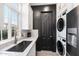 Modern kitchen with sleek appliances, white countertops, and stacked washer and dryer at 201 S Greenfield Rd, Mesa, AZ 85206