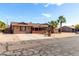 Single-story home with a well-kept lawn and mature palm trees, presenting a welcoming curb appeal at 2031 S Cactus Rd, Apache Junction, AZ 85119