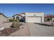 Single-story home with a two-car garage, desert landscaping, and a well-maintained lawn at 2159 Leisure World --, Mesa, AZ 85206