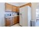 Functional kitchen with wooden cabinets and a white refrigerator at 2159 Leisure World --, Mesa, AZ 85206