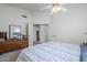 Bright main bedroom showcasing a dresser with mirror, ceiling fan, and ensuite bathroom access at 2159 Leisure World --, Mesa, AZ 85206