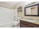 Clean bathroom features a tiled shower-tub, decorative shelf, and granite vanity at 21960 N 70Th Dr, Glendale, AZ 85310