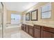 This bathroom features tile floors, double sinks, granite countertops and a soaking tub at 21960 N 70Th Dr, Glendale, AZ 85310