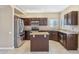 Well-lit kitchen features granite countertops, stainless steel appliances, and a functional center island at 21960 N 70Th Dr, Glendale, AZ 85310