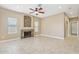 Living room featuring a stone fireplace, tile flooring, and a ceiling fan at 21960 N 70Th Dr, Glendale, AZ 85310