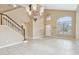 Bright living room with high ceilings, tile flooring, and staircase at 21960 N 70Th Dr, Glendale, AZ 85310