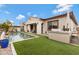 Beautiful backyard featuring a pool, artificial grass, and an outdoor kitchen area for entertaining guests at 22854 E Sonoqui Blvd, Queen Creek, AZ 85142