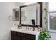 Well-lit bathroom vanity featuring a large mirror, ample counter space, and decorative plants at 22854 E Sonoqui Blvd, Queen Creek, AZ 85142