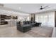 Open-concept living room showcases a plush sectional sofa, modern ceiling fan, and seamless flow into the kitchen at 22854 E Sonoqui Blvd, Queen Creek, AZ 85142