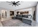 Spacious living room featuring a large sectional sofa, ceiling fan and view into the playroom and kitchen at 22854 E Sonoqui Blvd, Queen Creek, AZ 85142