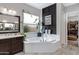 Serene main bathroom featuring a corner tub, contemporary fixtures, and natural lighting at 22854 E Sonoqui Blvd, Queen Creek, AZ 85142