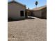 Backyard with rock groundcover, concrete block fence, and covered patio at 2634 N Saffron Cir, Mesa, AZ 85215