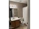 Neutral-toned bathroom featuring a single sink vanity, mirror with lighting, and toilet with shower featuring neutral color palette at 2634 N Saffron Cir, Mesa, AZ 85215