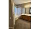 A carpeted bathroom featuring a tub/shower and a double sink vanity with mirror and lighting at 2634 N Saffron Cir, Mesa, AZ 85215