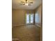 A carpeted living room with a ceiling fan, double french doors, and a window with blinds at 2634 N Saffron Cir, Mesa, AZ 85215