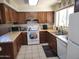 Functional kitchen featuring tiled floors, wooden cabinets, and essential appliances for cooking at 2839 W Villa Maria Dr, Phoenix, AZ 85053