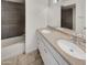 Well-lit bathroom featuring a double sink vanity, large mirror, bathtub, and tiled walls at 3009 W Laurel Ln, Phoenix, AZ 85029