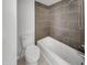 Clean bathroom featuring modern tile, a white toilet, and a bathtub with shower head at 3009 W Laurel Ln, Phoenix, AZ 85029