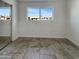 Well-lit bedroom with a large window, a sliding door closet, and neutral tiled floors at 3009 W Laurel Ln, Phoenix, AZ 85029