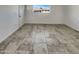 Well-lit, empty room features neutral tile floor, a window overlooking a street, and fresh, white paint at 3009 W Laurel Ln, Phoenix, AZ 85029