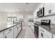 Modern kitchen with stainless steel appliances, granite countertops, and white cabinets at 35621 W San Alvarez Ave, Maricopa, AZ 85138