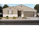 Inviting single-story home featuring neutral stucco, a two-car garage, and beautifully landscaped front yard at 37134 W La Paz St, Maricopa, AZ 85138