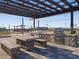 Outdoor kitchen featuring stainless steel grills, stone accents, covered seating and a patterned stone patio at 37326 W San Clemente St, Maricopa, AZ 85138