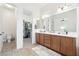 Bathroom featuring dual sinks, wood cabinets, walk-in closet, toilet and tile flooring at 4284 N 154Th Ave, Goodyear, AZ 85395