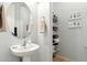 A well decorated half bathroom with a pedestal sink, a round mirror, and some towels at 4284 N 154Th Ave, Goodyear, AZ 85395