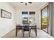 Bright dining room with a wooden table set, ceiling fan, and natural light from windows and sliding glass door at 4284 N 154Th Ave, Goodyear, AZ 85395