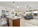 Stylish kitchen island with a sink and seating area overlooking the adjacent living room at 4284 N 154Th Ave, Goodyear, AZ 85395