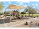 Community playground with sunshade, slide, and climbing equipment, surrounded by lush greenery and desert landscaping at 4284 N 154Th Ave, Goodyear, AZ 85395