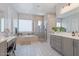 Bright bathroom featuring a soaking tub, glass-enclosed shower, dual vanities, and modern fixtures at 4330 S Neutron --, Mesa, AZ 85212