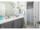 A dual sink bathroom with gray cabinets, white counters, and a shower with a glass door in the background at 4330 S Neutron --, Mesa, AZ 85212