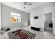 A well-lit bedroom with neutral paint, large window, ceiling fan, and a striped rug in the center at 4330 S Neutron --, Mesa, AZ 85212