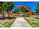 Playground featuring a unique orange climbing structure, surrounded by lush greenery and trees at 4330 S Neutron --, Mesa, AZ 85212