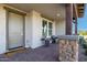 Covered front porch with seating area enhanced by decorative stone columns and tiled flooring at 4330 S Neutron --, Mesa, AZ 85212
