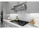 Modern kitchen detail featuring stainless steel hood, gas cooktop and white tile backsplash at 4330 S Neutron --, Mesa, AZ 85212