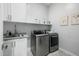 Well-equipped laundry room with modern washer and dryer, sink, white cabinetry, and shelving at 4330 S Neutron --, Mesa, AZ 85212