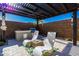 This cozy backyard boasts an outdoor kitchen with a grill, pergola, and comfortable lounge seating, perfect for entertaining at 4330 S Neutron --, Mesa, AZ 85212