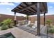 Pergola with outdoor kitchen, grill, seating area, and lush tropical landscaping at 4330 S Neutron --, Mesa, AZ 85212