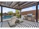 Outdoor kitchen with stainless steel grill, under a pergola with seating and a view of the pool at 4330 S Neutron --, Mesa, AZ 85212